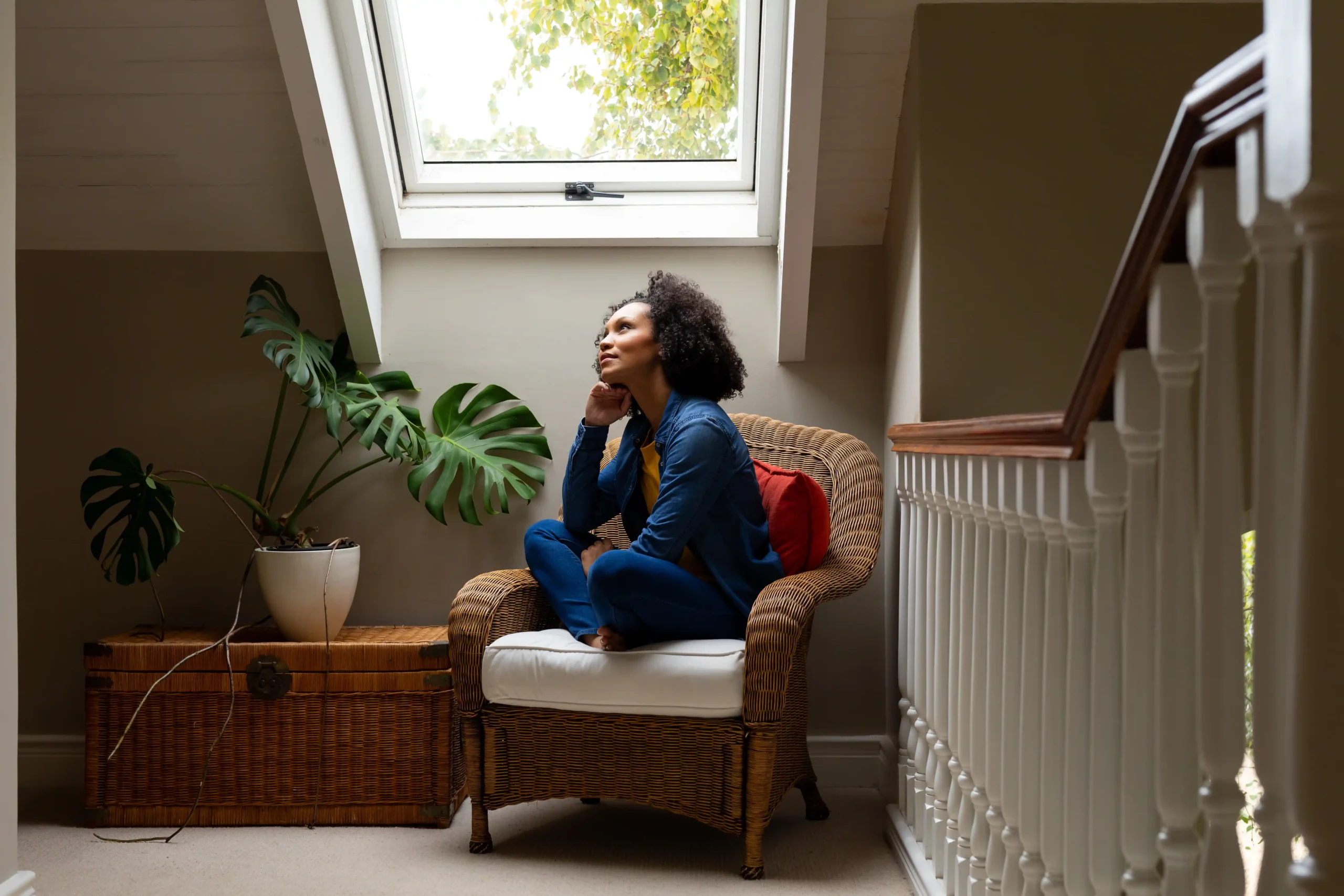 Woman sat in contemplation underneath skylight window